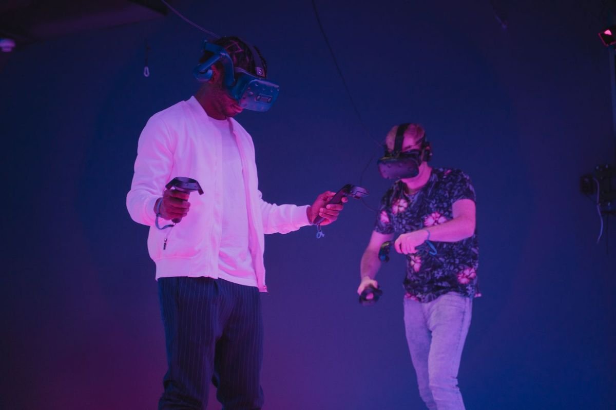 Two guys in VR headsets under purple light