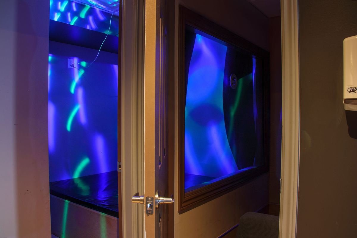 Blue neon light through the peep show window at Luxe