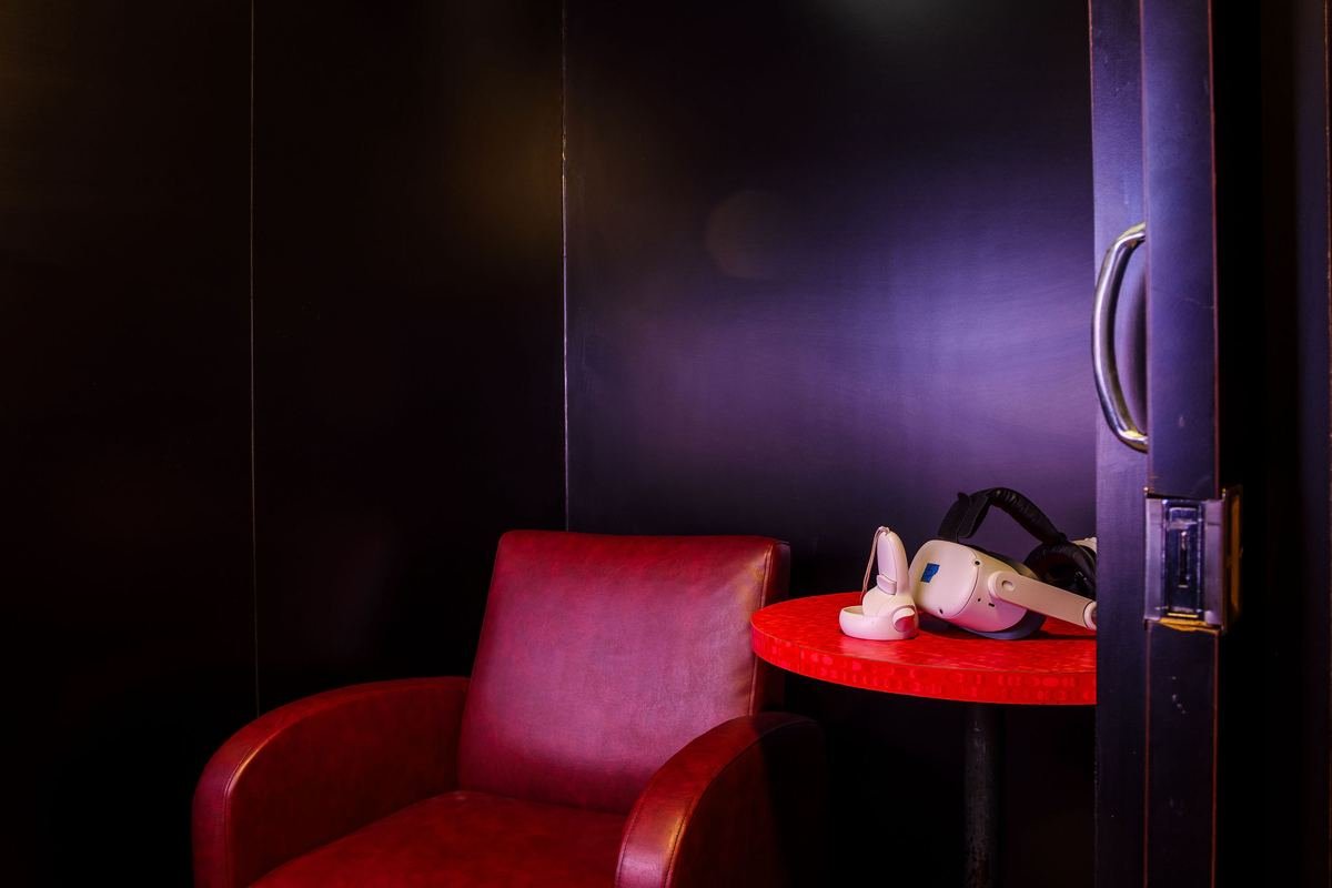 A private VR booth at Luxe with a red armchair and a headset ready on the table